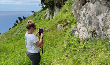 Photo of Dr Emma Horn taking a photo of the volcanic deposit